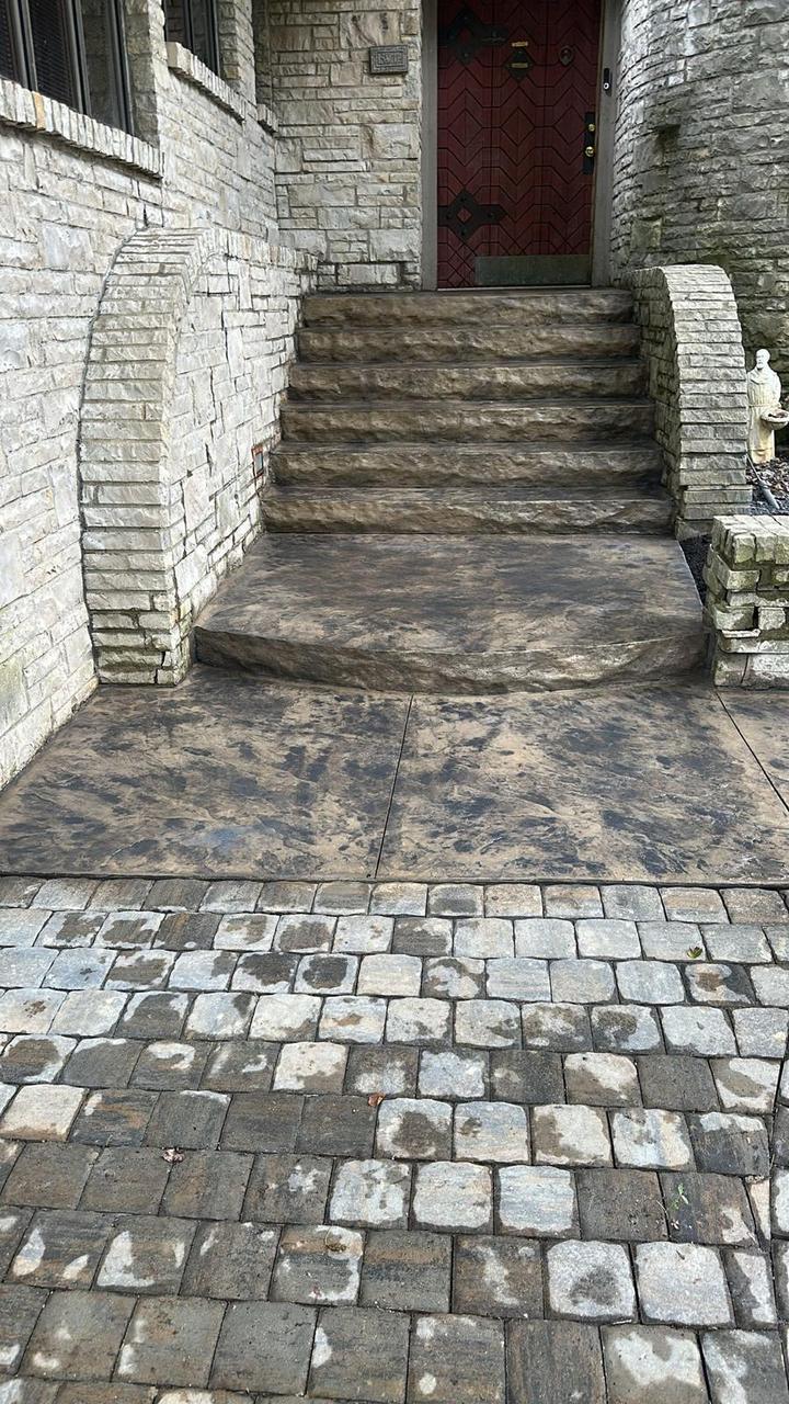 Stamped concrete front entry steps and walkway at a stone home