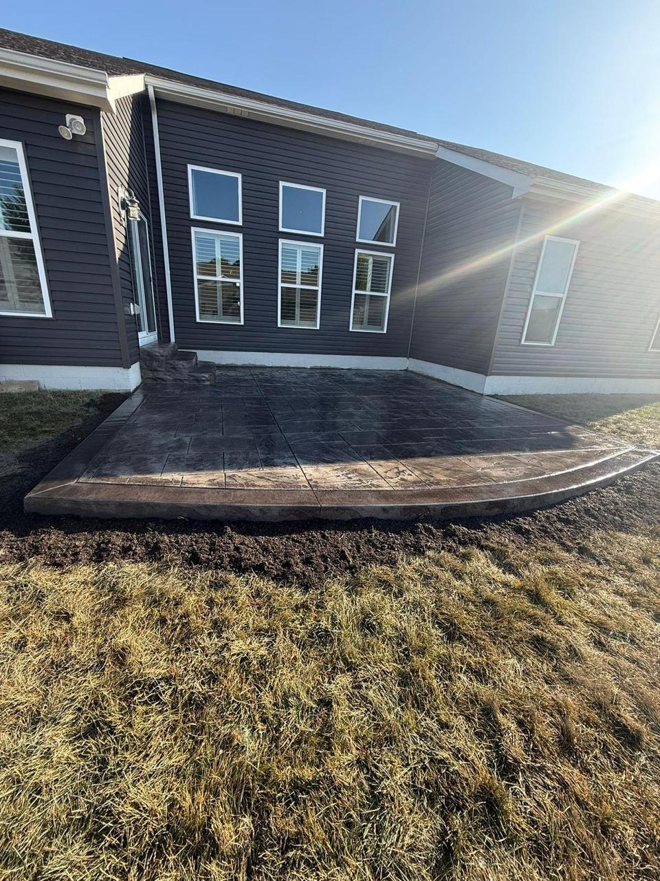 Charcoal stamped concrete patio with contrasting tan border