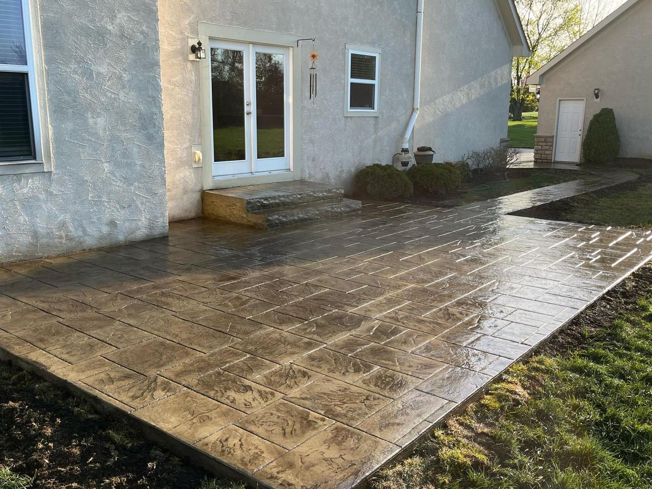 Golden tan stamped concrete patio and walkway at french doors