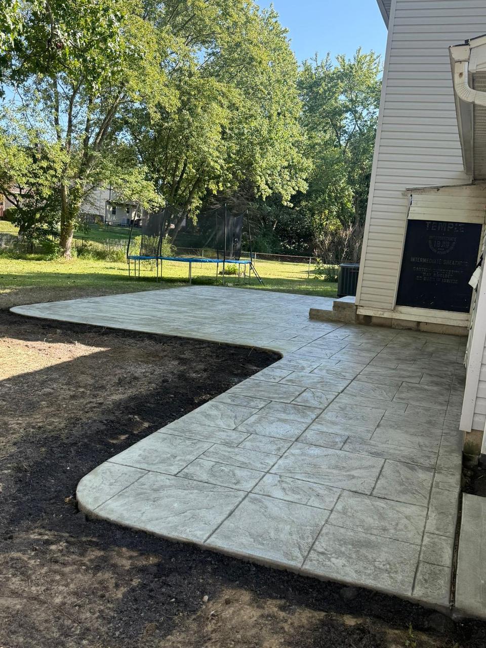 Light grey stamped concrete patio with sweeping curved edge