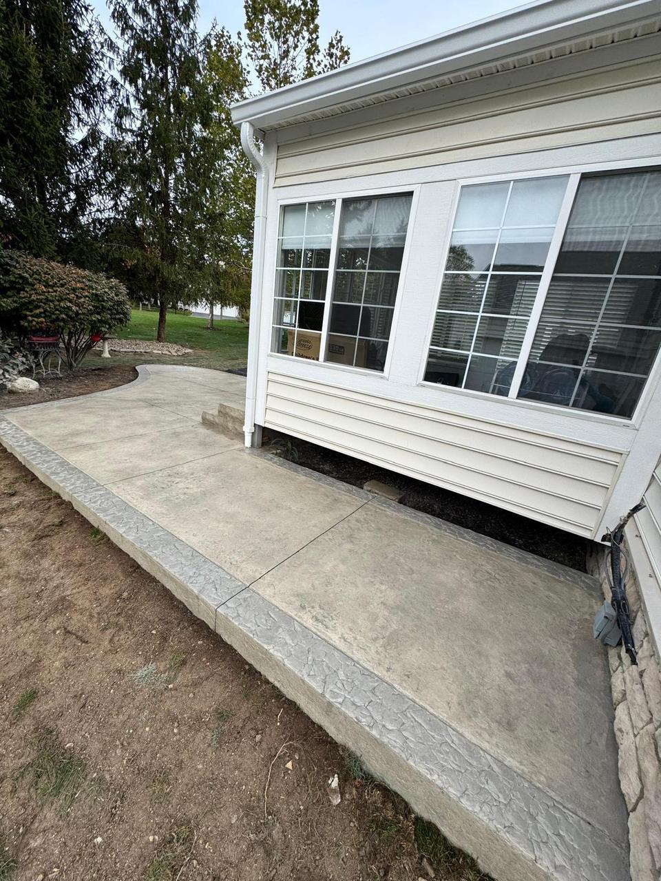 Stamped concrete walkway alongside a sunroom